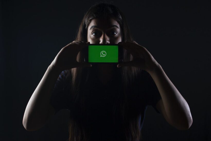 woman holding phone with whatsapp scaled 1